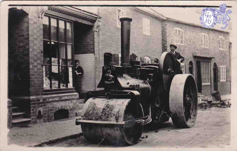 29-114 Steam Road Roller outside 18 Bushloe End with Emma Holt nee Bates in shop doorway c 1940