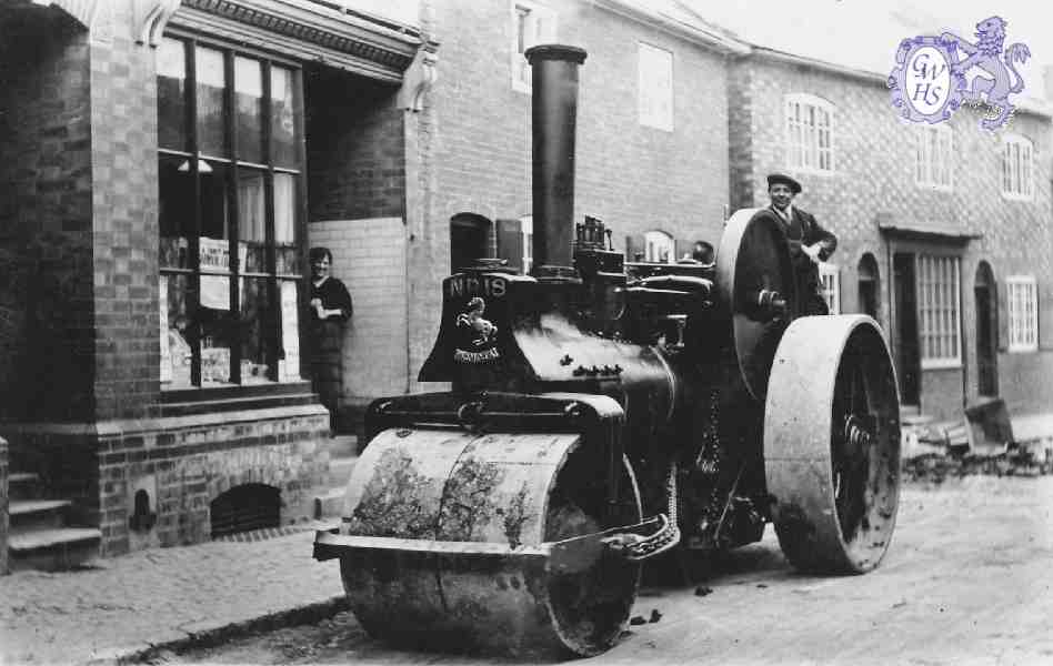 29-114a Steam Road Roller outside 18 Bushloe End with Emma Holt nee Bates in shop doorway c 1940